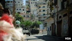 Lebanese army armored vehicles idle on Syria Street between the Jebel Mohsen and Bab Tabbaneh neighborhoods of Tripoli, Lebanon, August 23, 2012. (VOA/Jeff Neumann)