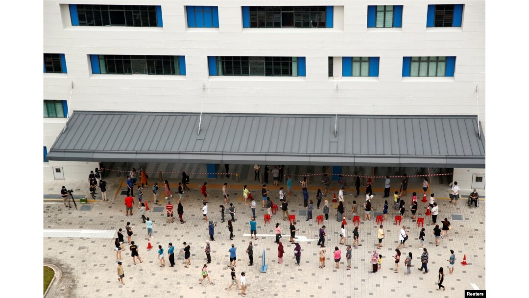 Para pemilih di tempat pemungutan suara selama pemilihan umum Singapura, di tengah wabah COVID-19, di Singapura, 10 Juli 2020. (Foto: REUTERS/Edgar Su)
