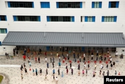 Para pemilih di tempat pemungutan suara selama pemilihan umum Singapura, di tengah wabah COVID-19, di Singapura, 10 Juli 2020. (Foto: REUTERS/Edgar Su)