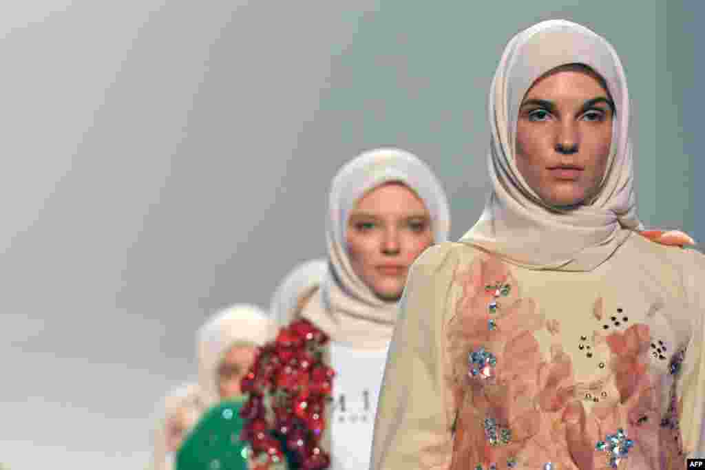 Models present a creation by Minaz on the catwalk during Arab Fashion Week in the United Arab Emirate of Dubai.