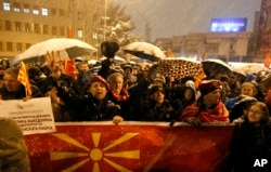 People carry banners and wave flags during a protest against the change of the country's constitutional name, in front of the Parliament building in Skopje, Macedonia, Feb. 27, 2018.
