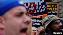 Demonstrators march past Trump Tower as they protest through Manhattan demanding U.S. President Donald Trump release his tax returns, in New York, April 15, 2017.