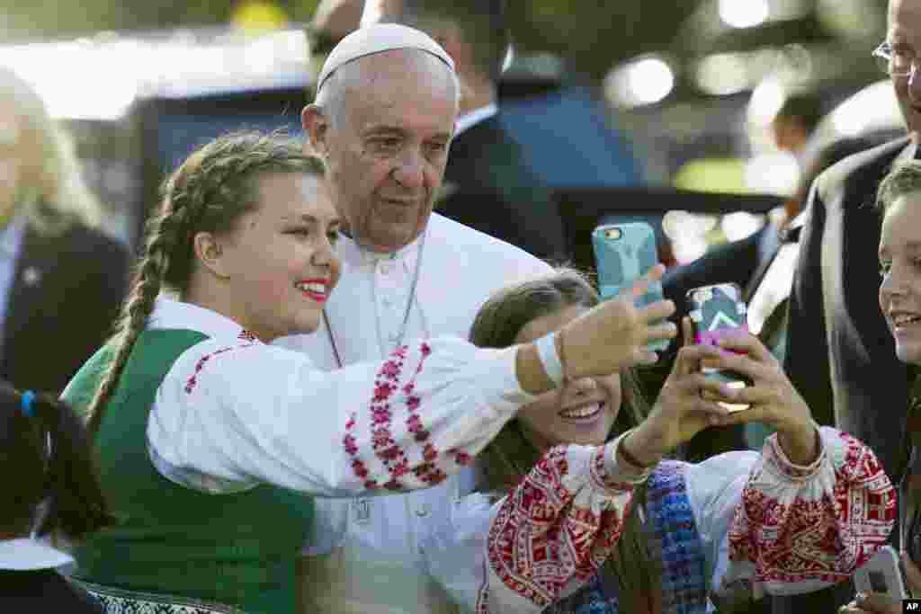 Children of parents who work at the Lithuanian Embassy take selfies with Pope Francis as he departs the Apostolic Nunciature, the Vatican&#39;s diplomatic mission in Washington.