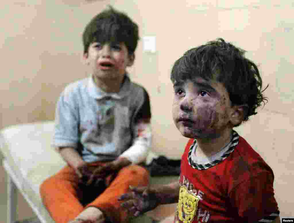Injured children cry after, according to activists, two barrel bombs were thrown by forces loyal to Syria's president Bashar Al-Assad in Aleppo.