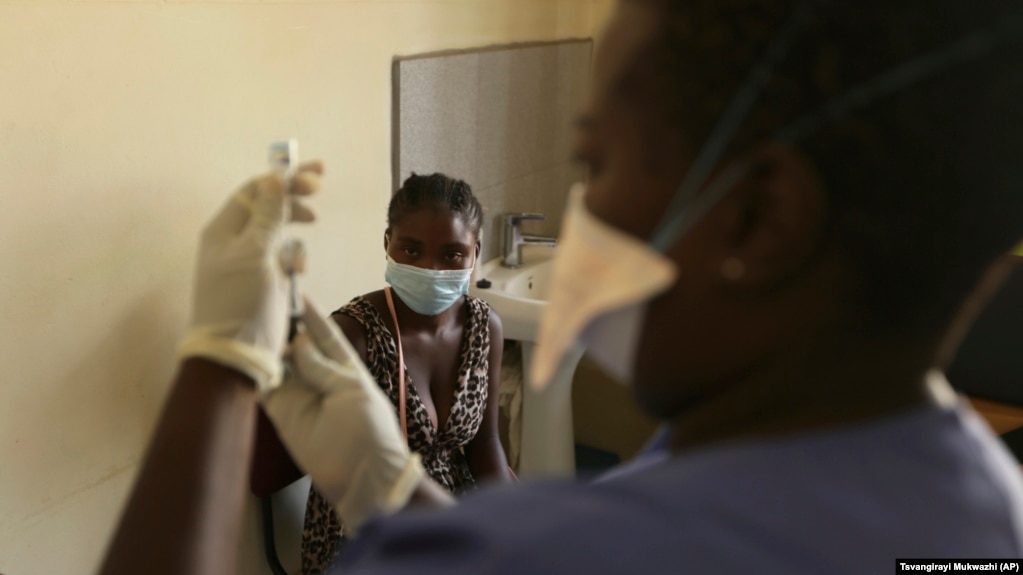 A young woman prepares to get vaccinated against COVID-19 at a health center in Harare, Zimbabwe on Friday, Sept, 24, 2021. (AP Photo/Tsvangirayi Mukwazhi)