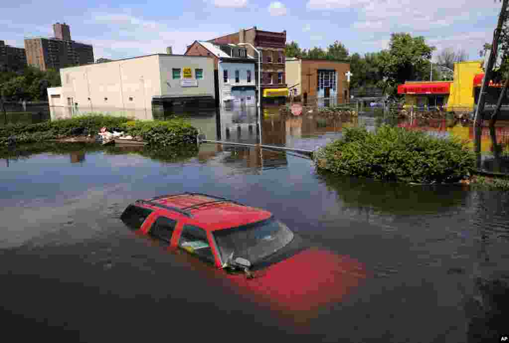 8月30日：在美国新泽西周的帕特森，艾琳飓风过后数日，帕萨伊克河泛滥的大水仍未消退，街头汽车遭淹，包括这辆雪佛莱SUV。