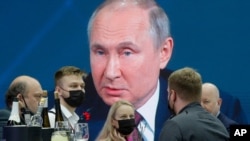 Journalists gather in the press center as they listen to Russian President Vladimir Putin speaking, at the St. Petersburg International Economic Forum in St. Petersburg, Russia, June 4, 2021.