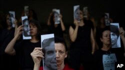 FILE—Relatives and supporters of Israeli hostages held by Hamas in Gaza hold photos of their loved ones during a performance calling for their return in Tel Aviv, Israel, May 23, 2024.