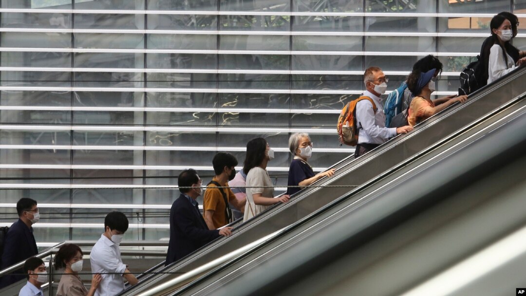 People wearing face masks to help protect against the spread of the coronavirus ride an escalator as they arrive at the Seoul Railway Station in Seoul, South Korea, Monday, Aug. 24, 2020.South Korea counted its 11th straight day of triple-digit…