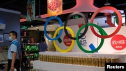 FILE - Olympic rings are seen above products of The Coca-Cola Company, a corporate sponsor of the Beijing 2022 Olympic Games, at a supermarket in Beijing, China, July 30, 2021. 