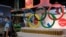 FILE - Olympic rings are seen above products of The Coca-Cola Company, a corporate sponsor of the Beijing 2022 Olympic Games, at a supermarket in Beijing, China, July 30, 2021. 