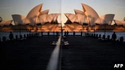 Warga menikmati matahari terbenam di landmark dekat Sydney Opera House yang biasanya dipenuhi oleh para wisatawan di Sydney, Australia (foto: dok).