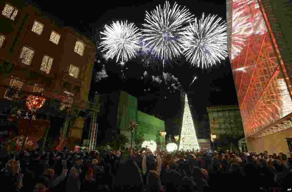 Lebanese watch a firework display the New Year's celebrations in downtown Beirut, Sunday, Jan. 1, 2012. (AP)