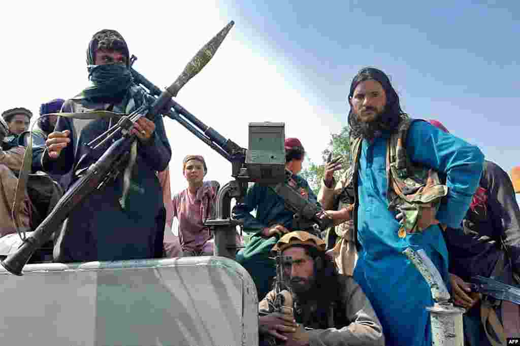 Taliban fighters sit over a vehicle on a street in Laghman province, Afghanistan, Aug. 15, 2021. 