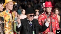 FILE - Designer Vyacheslav "Slava" Zaitsev, center left, reacts after displaying his creations during Fashion Week in Moscow, Russia, March 10, 2018. 