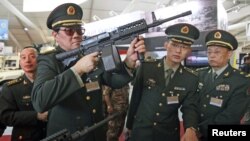 Chinese officers check rifles of ARES Defense Systems, Inc from the U.S. at the Special Operations Forces Exhibition and Conference at King Abdullah I Airbase in Amman, Jordan, May 8, 2012. 