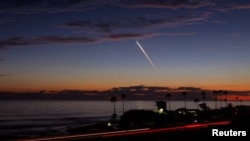 Un lanzamiento nocturno de un cohete SpaceX Falcon 9 que transporta 20 satélites Starlink V2 Mini, desde el Complejo de Lanzamiento Espacial en la Base de la Fuerza Espacial Vandenberg, se ve sobre el Océano Pacífico desde Encinitas, California, EEUU, el 23 de junio de 2024.