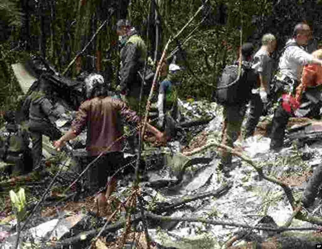 Para petugas penyelamat memeriksa puing-puing pesawat Trigana Air Service yang jatuh di daerah Pegunungan Bintang, Papua (18/8).