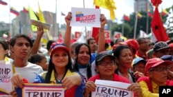Government supporters hold signs with a message that reads in Spanish, "Trump unblock Venezuela," during a protest against U.S. sanctions, in Caracas, Venezuela, Aug. 7, 2019. 