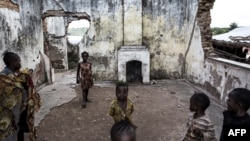 Des enfants jouent dans les ruines d'un camp de déplacés internes, à Kalemie en RDC, le 20 mars 2018.