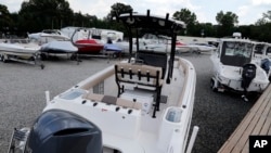 FILE - New boats are on display at a dealership in Chester, Va., July 11, 2018. Some U.S. manufacturers are feeling the impact of tariffs the Trump administration has imposed on products from China, Europe, Mexico, Canada, India and Russia, and of retaliatory tariffs.