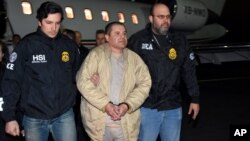 In this photo provided by U.S. law enforcement, authorities escort Joaquin "El Chapo" Guzman, center, from a plane to a waiting caravan of SUVs at Long Island MacArthur Airport, Jan. 19, 2017, in Ronkonkoma, N.Y.