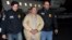 In this photo provided by U.S. law enforcement, authorities escort Joaquin "El Chapo" Guzman, center, from a plane to a waiting caravan of SUVs at Long Island MacArthur Airport, Jan. 19, 2017, in Ronkonkoma, N.Y.