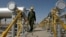 FILE - Oil technician Majid Afshari makes his way to the oil separator facilities in Iran's Azadegan oil field southwest of Tehran, April 15, 2008.