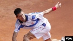 Novak Djokovic mengembalikan bola kepada Guillermo Garcia-Lopez di turnamen tenis Madrid Terbuka hari Kamis (5/5).