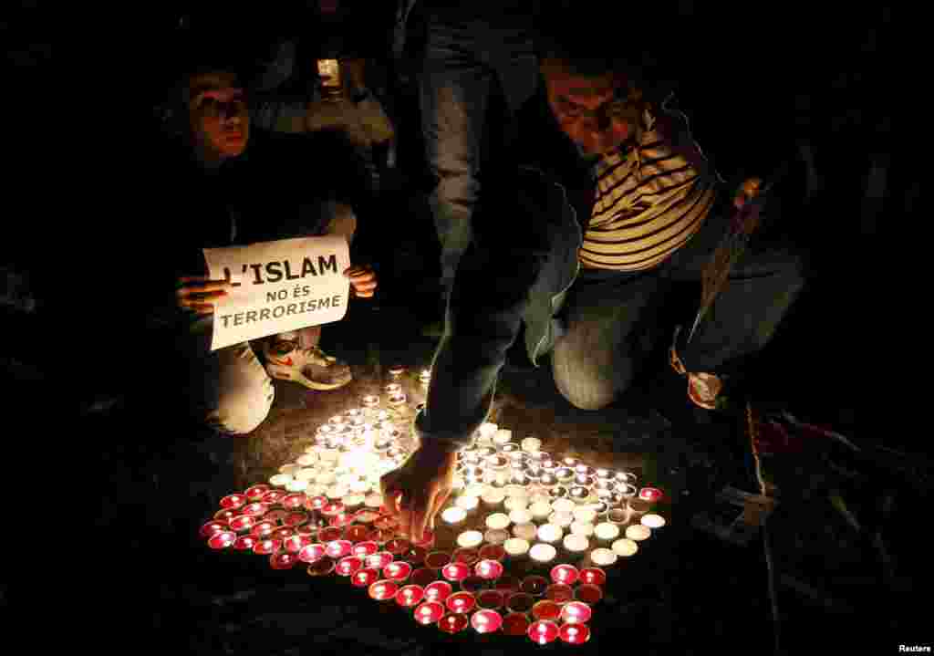 Velas são acesas na forma da bandeira francesa em lembrança às vítimas dos ataques de Paris na &nbsp;Praça&nbsp;de&nbsp;Sant Jaume, em Barcelona, na Espanha. O cartaz diz &quot;Islã não é terrorismo&quot;.&nbsp;