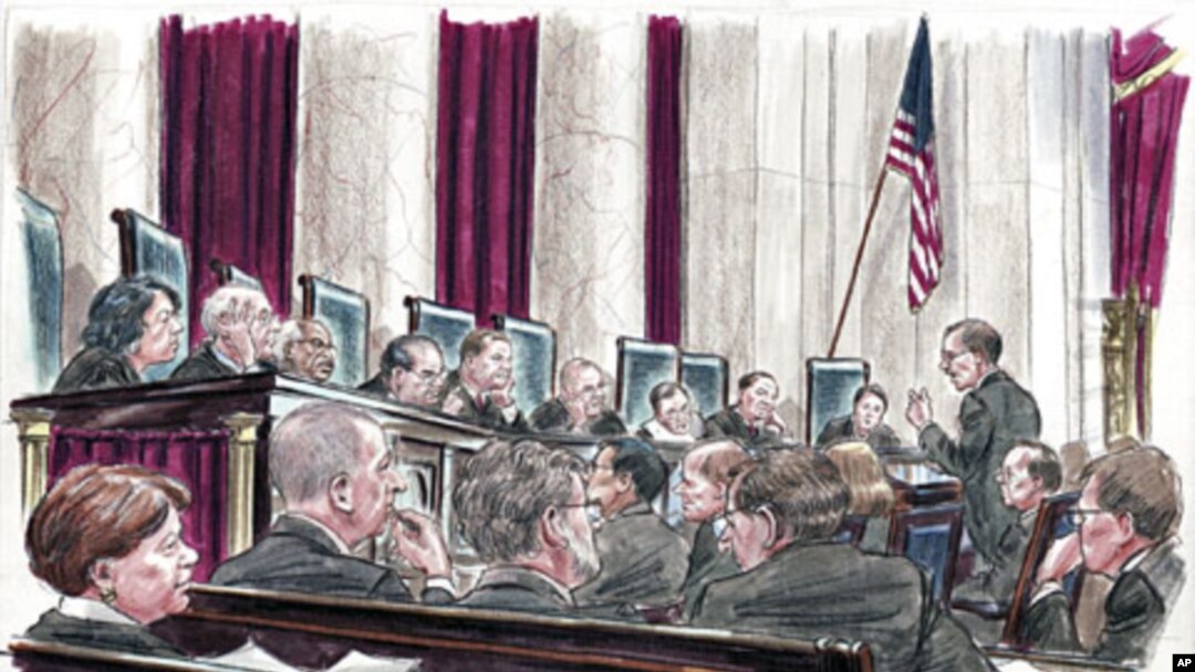 In this courtroom illustration, U.S. Solicitor General Donald Verrilli (R) speaks at the lectern to members of the U.S. Supreme Court in Washington, March 27, 2012