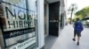 A pedestrian walks past a Zara store with a large "Now Hiring," sign in the window, Oct. 12, 2020, along the famed Lincoln Road area in Miami Beach, Florida. 