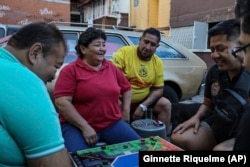 From left, Salvador Espinosa, Rosa Espinosa, Diego Castillo, Erik Cisneros and Ulises Tiscareño share a joke while playing poleana, a board game invented in prison in Mexico City, Sunday, Dec. 8, 2024. (AP Photo/Ginnette Riquelme)