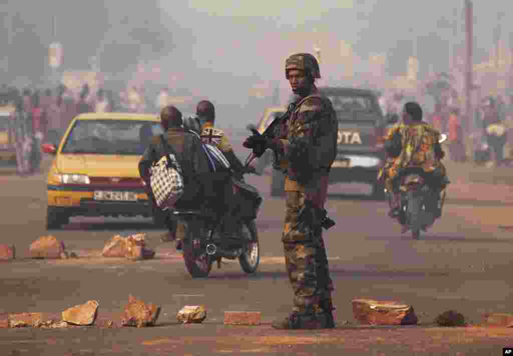 A French soldier waves through traffic as he mans a roadblock in the Miskine neighborhood of Bangui, Central African Republic, Jan. 6, 2014. 