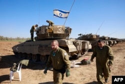 Tentara Israel berkumpul dengan kendaraan mereka di perbatasan dengan Jalur Gaza pada 7 Januari 2024, di tengah pertempuran Israel-Hamas yang terus berlanjut.