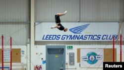 Ashley Watson, 29, from UK, attempts to set a new Guinness World Record for the "Farthest backflip between horizontal bars" in Leeds, Britain, November 12, 2021. Courtesy of Guinness World Records 2021/Michael Bowles/Handout via REUTERS 