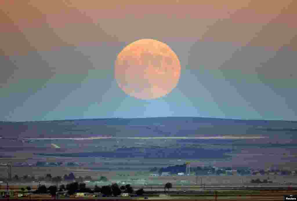 A full moon rises over the Turkish-Syrian border line close to the Syrian town of Kobani. 