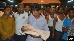 A man holds the lifeless body of his child outside Baba Raghav Das Medical College Hospital in Gorakhpur, in the northern Indian state of Uttar Pradesh, Aug. 11, 2017.