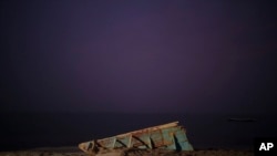 FILE - The wreck of a traditional Mauritanian fishing boat, known as a pirogue, also used by migrants to reach Spain's Canary Islands, sits on a beach near Nouadhibou, Mauritania, December 2, 2021.