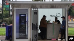 Government employees open the customer service area of a Chivo digital wallet machine, which exchanges cash for Bitcoin cryptocurrency, at Las Americas Square in San Salvador, El Salvador, Tuesday, Sept. 7, 2021. 