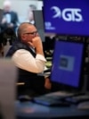 FILE - People work on the floor at the New York Stock Exchange in New York, March 4, 2025. 