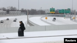 Cars drive down an icy highway as cold weather moves through Dallas, Texas, Jan. 31, 2023. 