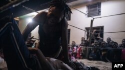 FILE - Voodoo wrestler Maitresse Libondans faces off with an opponent in a schoolyard in Selemenbao district in Kinshasa, on July 29, 2023.