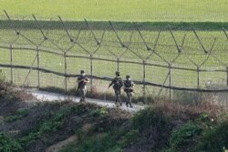 South Korean army soldiers patrol along the barbed-wire fence in Paju, South Korea, near the border with North Korea, June 15, 2020.