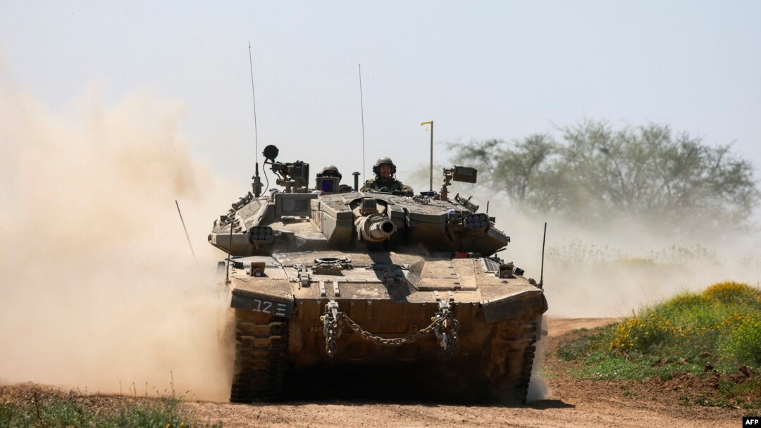 FILE - Sebuah tank Israel meluncur di sepanjang perbatasan dengan wilayah Palestina, selatan Israel dengan Jalur Gaza, 16 April 2024, di tengah konflik yang sedang berlangsung antara Israel dan kelompok militan Hamas. (Menahem KAHANA/AFP)