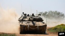 FILE - Sebuah tank Israel meluncur di sepanjang perbatasan dengan wilayah Palestina, selatan Israel dengan Jalur Gaza, 16 April 2024, di tengah konflik yang sedang berlangsung antara Israel dan kelompok militan Hamas. (Menahem KAHANA/AFP)