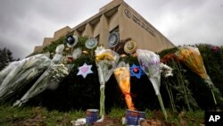 A makeshift memorial of flowers rests on bushes outside the Tree of Life synagogue in Pittsburgh, Nov. 20, 2018. On Thanksgiving, some Americans will celebrate new friendships forged in the wake of tragedy. 