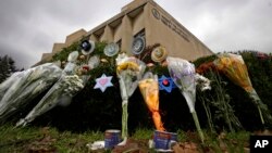 FILE - A makeshift memorial of flowers rests on bushes outside the Tree of Life synagogue in Pittsburgh, Nov. 20, 2018. 