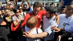 David Hernandez (C) is hugged by family members upon his arrival at the Kota Kinabalu International Airport in Sabah, Malaysia, May 13, 2016.