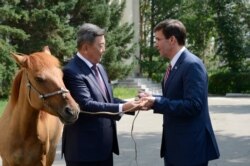 Mongolian Defense Minister Nyamaa Enkhbold, left, presents a horse as a gift to U.S. Defense Secretary Mark Esper at the Defense Ministry in Ulaanbaatar, Aug. 8, 2019.